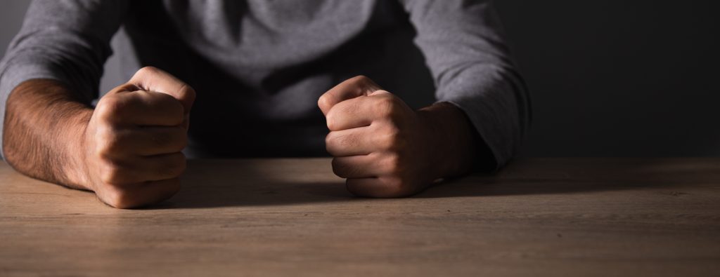 man with balled fists and feeling angry