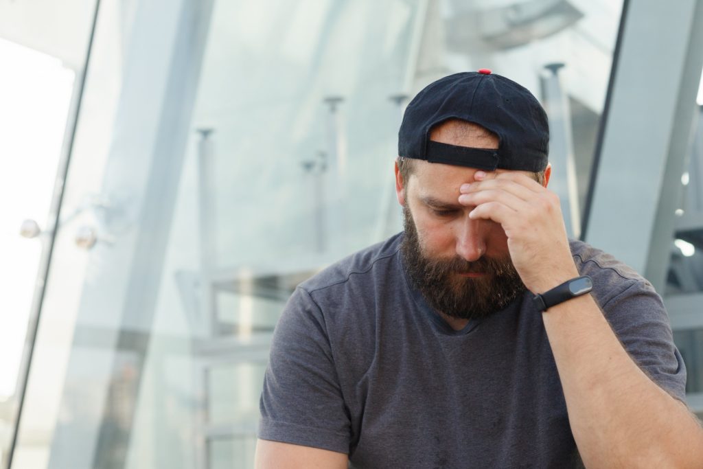 Understanding Dry Drunk Syndrome 1 man with untreated alcoholism sits with his head resting on his hand