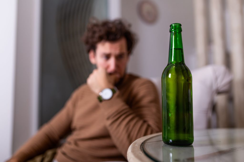 Understanding Dry Drunk Syndrome 3 man is tempted to return to poor coping habits and thinks about drinking beer next to him